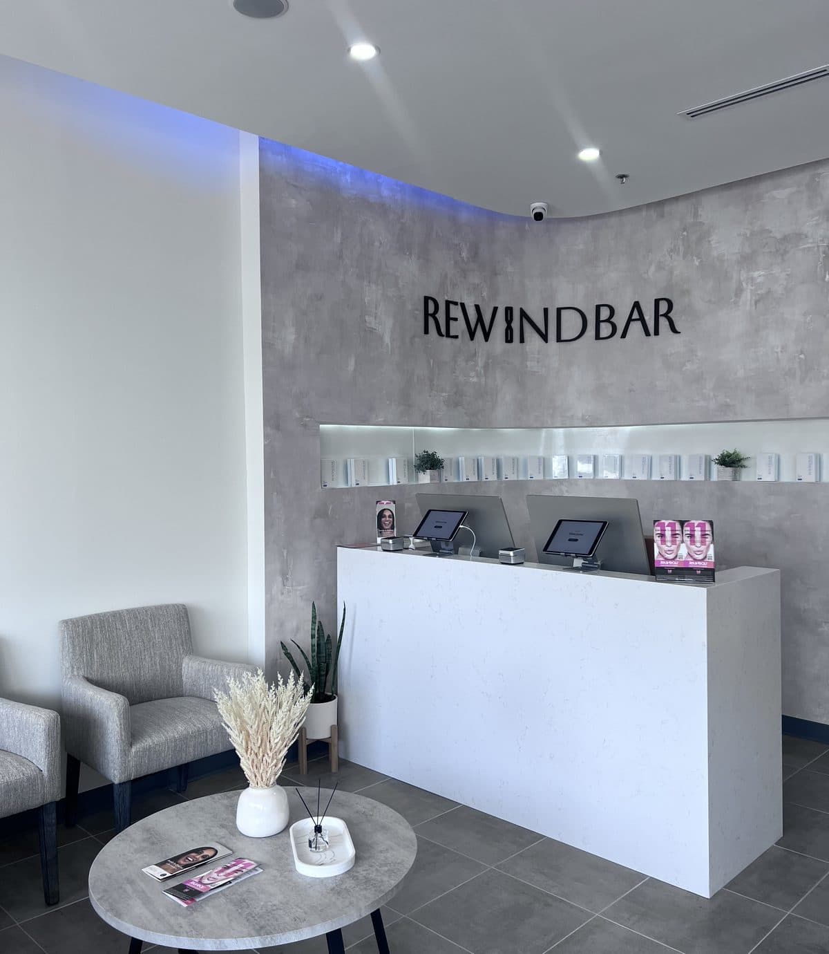 The reception desk and wordmark wall inside Rewind Bar in South Plainfield