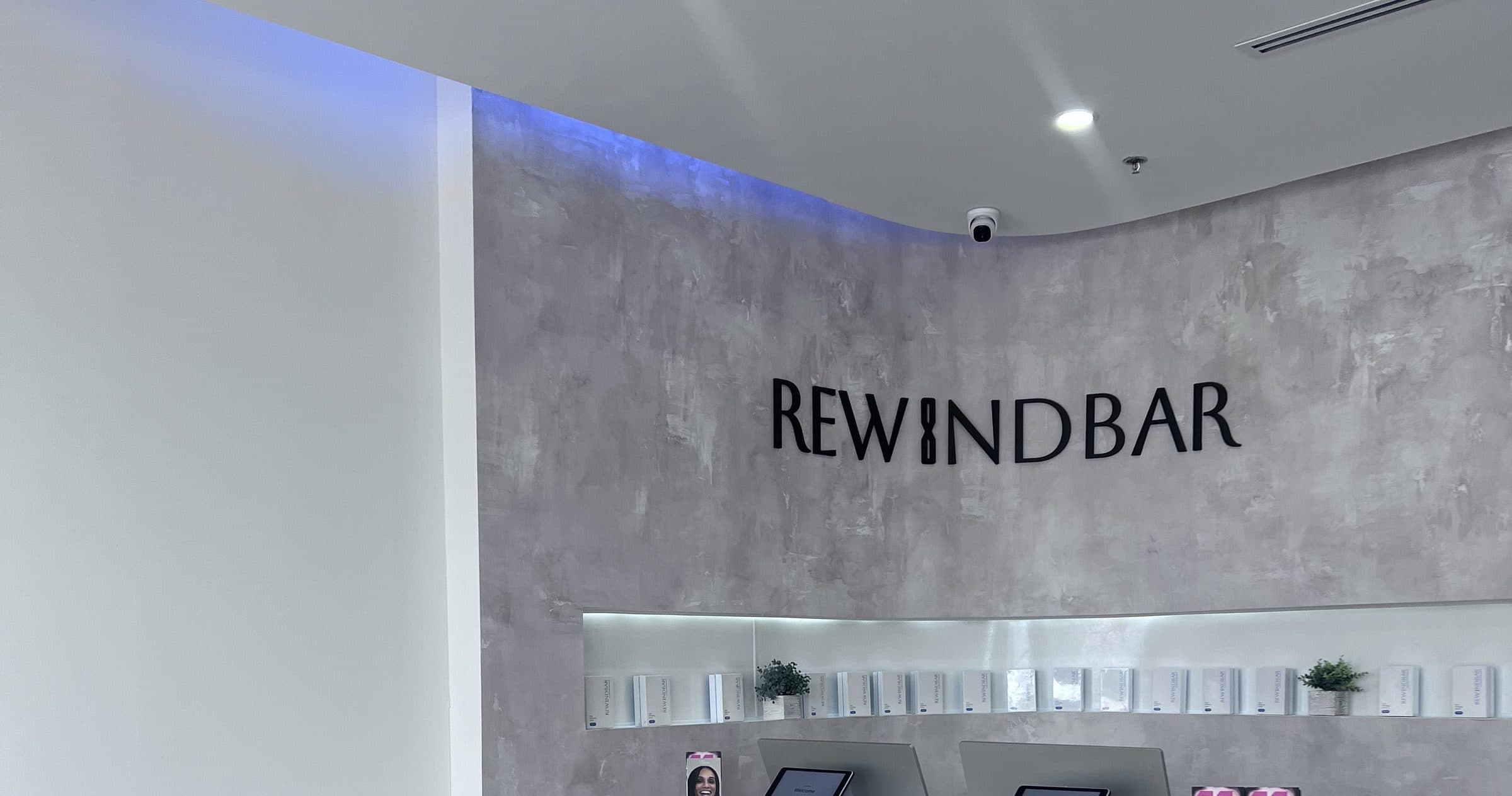 The reception desk and wordmark wall inside Rewind Bar in South Plainfield