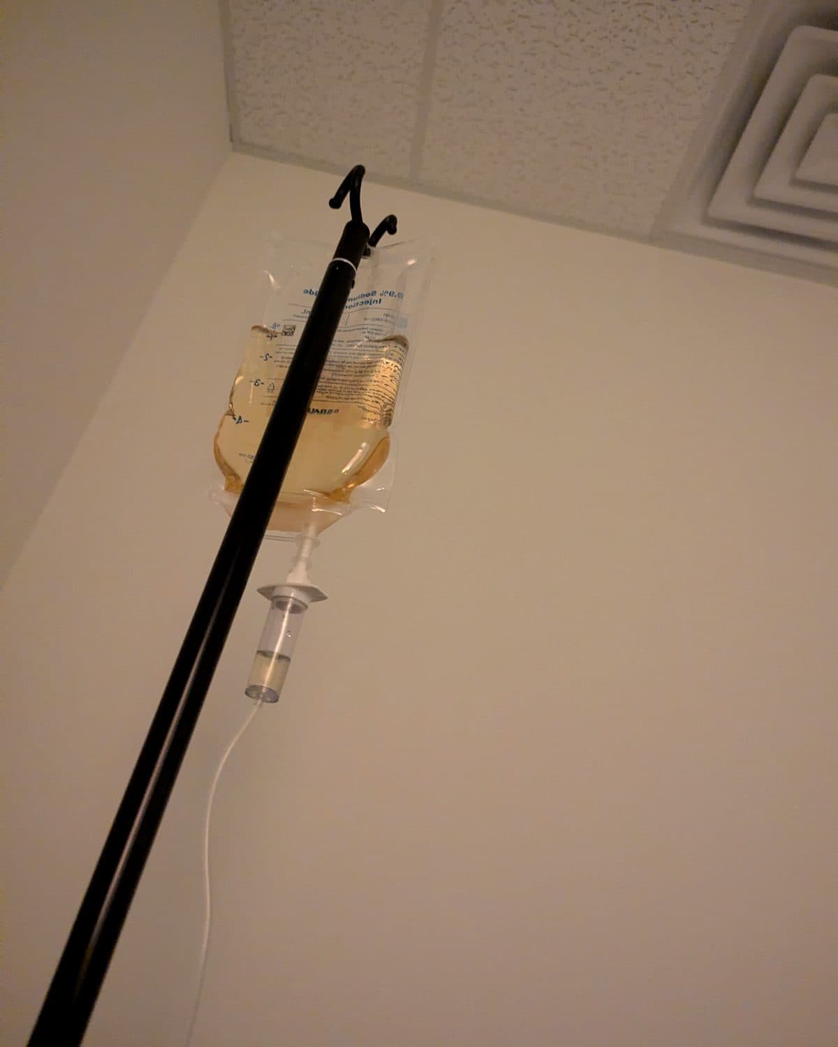 An IV drip bag hanging from a stand in a Rewind Bar treatment room