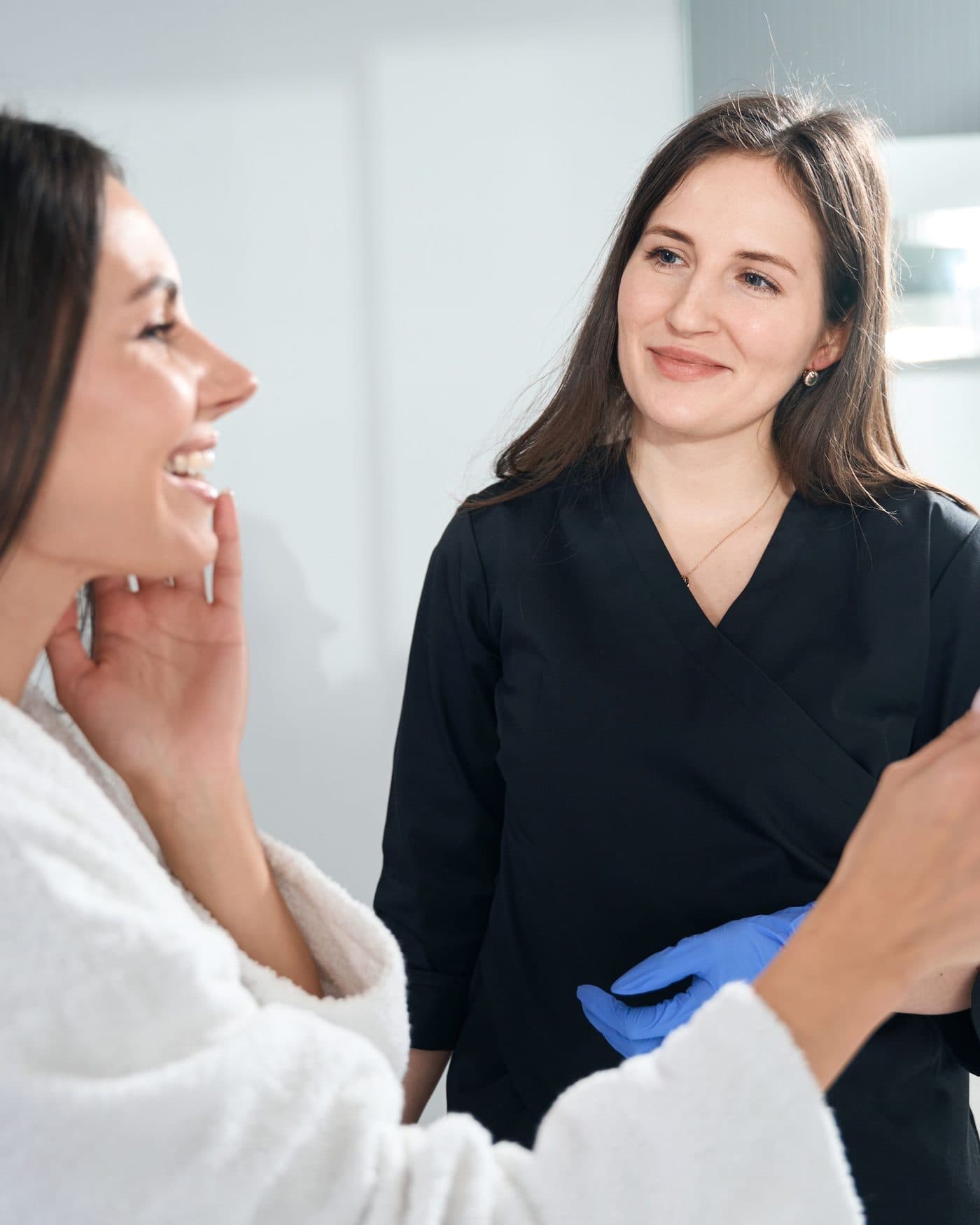 Provider showing a client her skin in a hand mirror after a treatment